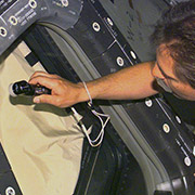 Space Shuttle window being inspected for orbital debris impacts. Credit: NASA.